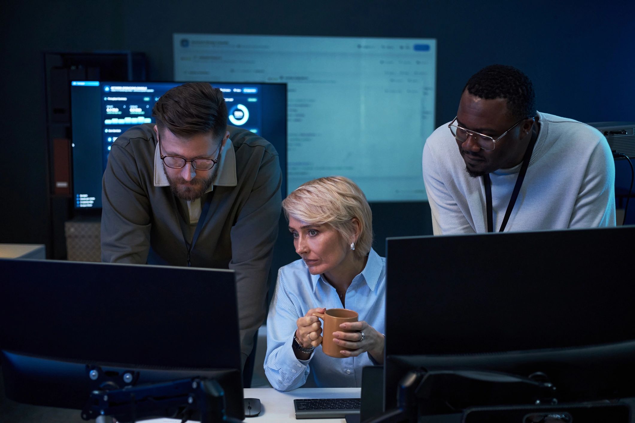 Engineering team monitoring systems in a technical control room